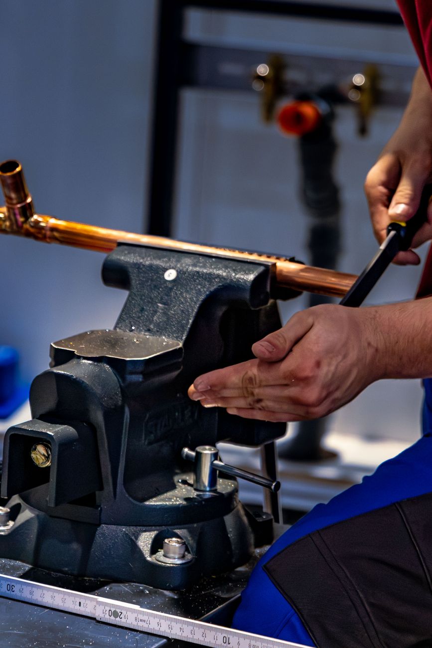 A plumber bending copper pipe